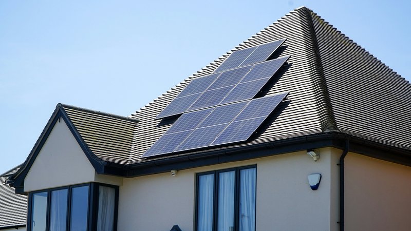 Zonnepaneel met stekker aan een balkonreling bevestigd